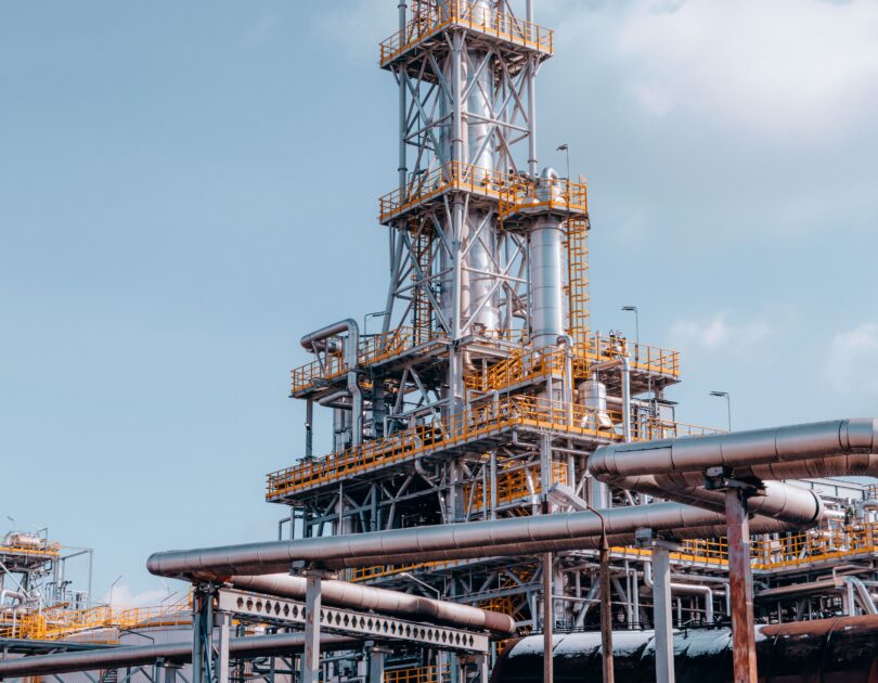 ATEX-rated industrial refinery environment with pipelines and storage tanks